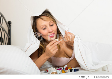 Female eating sweets in bed Female eating sweets in bed 14880689