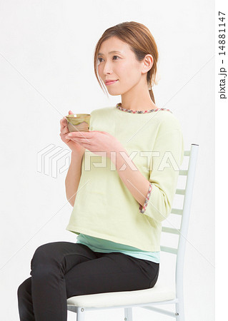 椅子に座ってコーヒーを飲むミドルの女性 椅子に座ってコーヒーを飲むミドルの女性 14881147