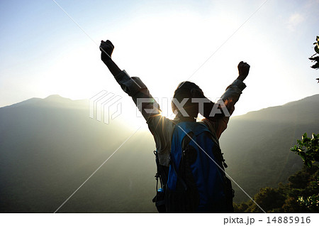 cheering woman hiker open arms at mountain peak 14885916