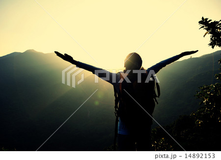 cheering woman hiker open arms at mountain peak 14892153