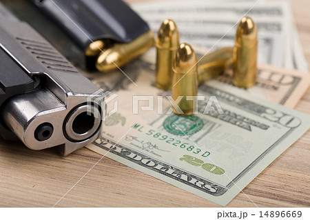 gun with bullet on US dollar banknotes gun with bullet on US dollar banknotes 14896669