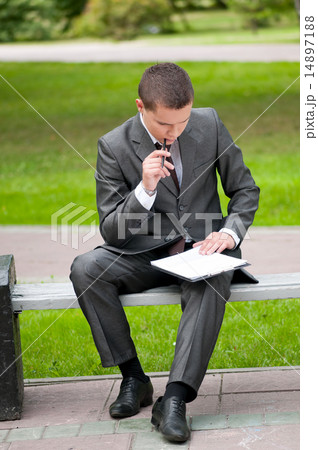 business man working with papers at park. Student 14897188