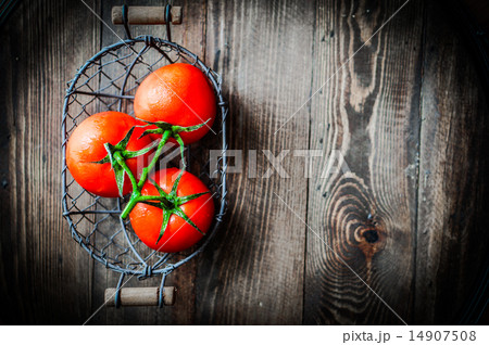 Fresh tomatoes in antique basket on wooden background 14907508