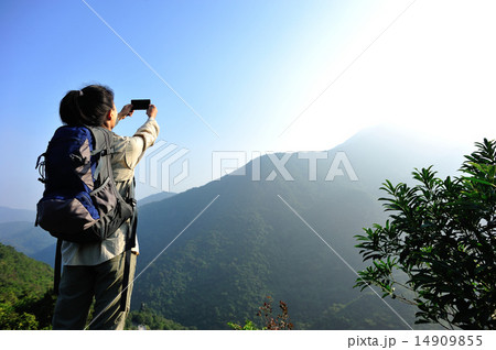 woman hiker taking photo with smart phone woman hiker taking photo with smart phone 14909855