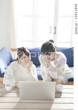 リビングでノートパソコンを見る20代女性2人 リビングでノートパソコンを見る20代女性2人 14911640