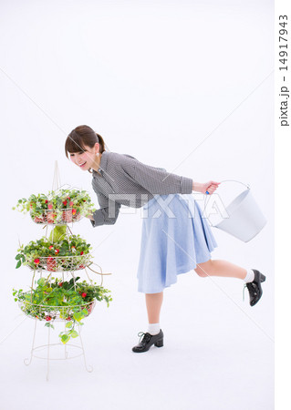 バケツを持って苺のバスケットを見ている笑顔の若い女性 バケツを持って苺のバスケットを見ている笑顔の若い女性 14917943