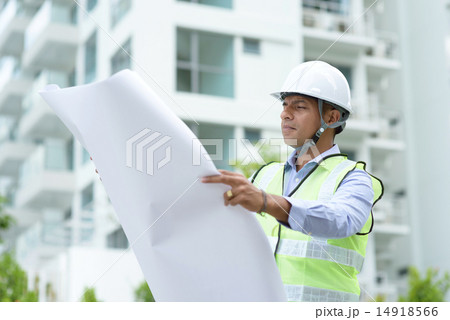 Indian construction engineer looking at site plans 14918566