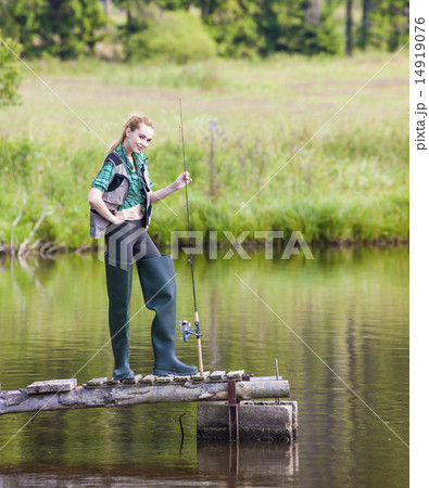 young woman fishing on pier at pond 14919076