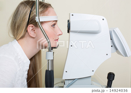 Young woman having her eyes examined by an eye handsome elderly doctor 14924036