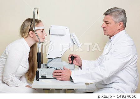 Young woman having her eyes examined by an eye handsome elderly doctor 14924050