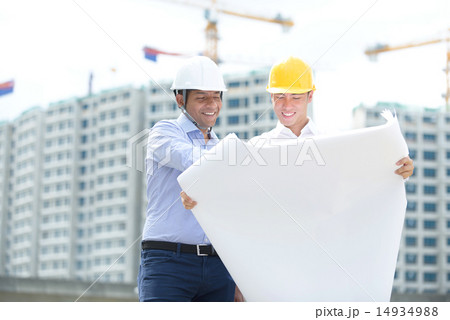 2 contractors looking at blueprints 14934988