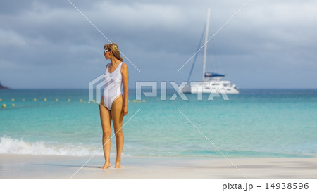 Woman in a white bathing suit on a tropical beach. 14938596