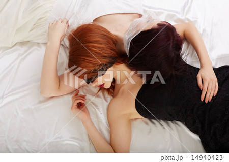 Sexual girlfriends hugging while lying in bed 14940423