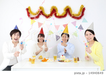 パーティーでクラッカーを鳴らす若い男女 14940649
