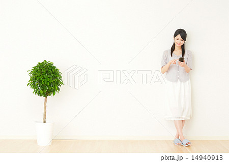 部屋でスマートフォンを使う女性 部屋でスマートフォンを使う女性 14940913