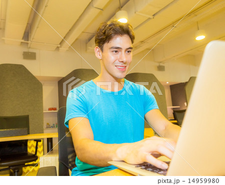 a male student using his laptop a male student using his laptop 14959980
