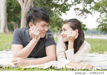 Young couple lying down and relaxing in a park. 14962425
