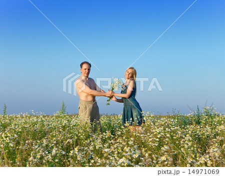 happy young pair in the field of chamomiles happy young pair in the field of chamomiles 14971069
