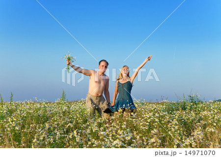 happy young pair in the field of chamomiles happy young pair in the field of chamomiles 14971070