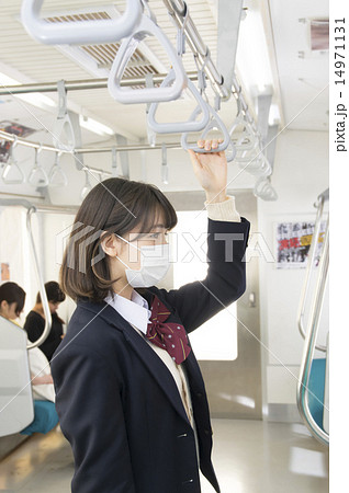 マスクをして電車に乗る女子高生の写真素材