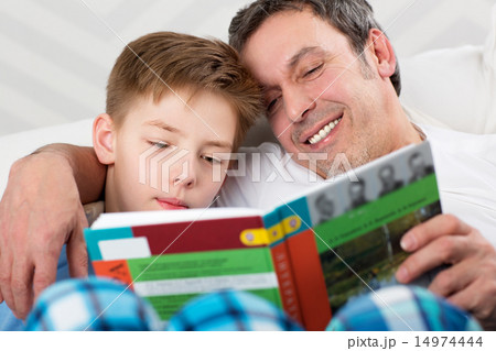 Son and father reading book together 14974444
