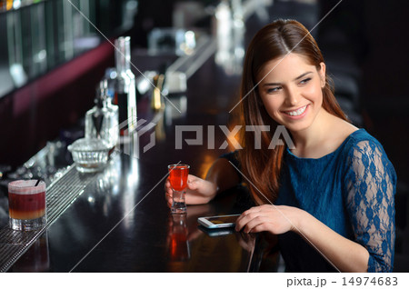 Young woman uses her phone in the bar Young woman uses her phone in the bar 14974683