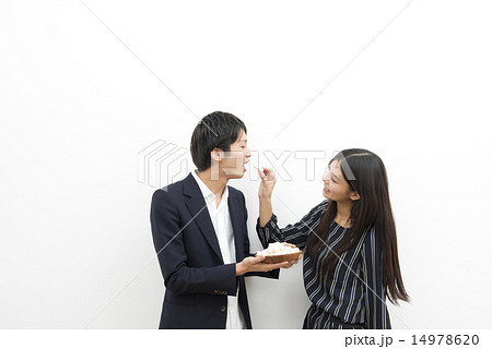 お菓子を食べさせあう男女の写真素材 お菓子を食べさせあう男女の写真素材