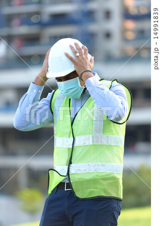 Indian construction worker having a headache Indian construction worker having a headache 14991839