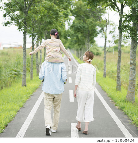 一本道で肩車をする親子の後姿の写真素材 一本道で肩車をする親子の後姿の写真素材