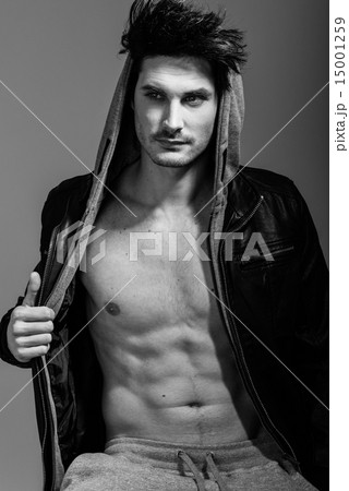 Athletic man wearing hoodie jacket. Studio shot 15001259