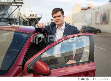 happy man posing with new car and showing keys happy man posing with new car and showing keys 15020005
