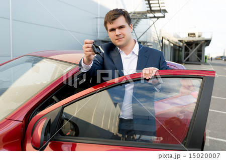 Portrait of happy businessman posing at car with keys Portrait of happy businessman posing at car with keys 15020007