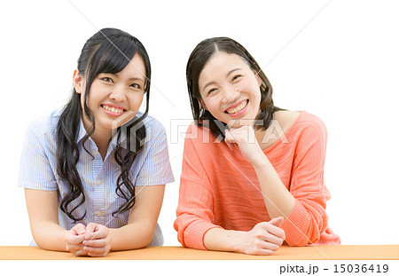 若い女性２人の仲良し立ちポーズの白バックイメージの写真素材
