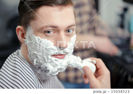 Client shaving at barber shop 15038523