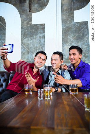 friends taking pictures in fancy night club 15043050