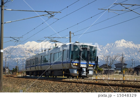雪の北アルプス立山連峰を背景に走る「あいの風鉄道」 15048329
