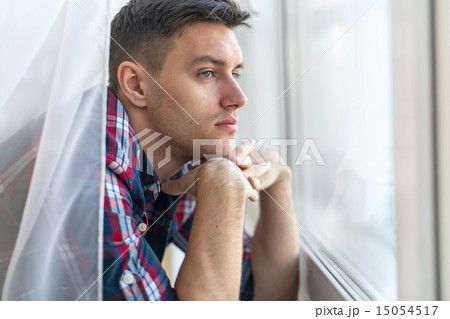 Handsome pensive man guy watching through the window concept sadness sorrow pain waiting 15054517