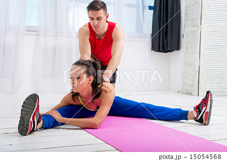 Active sportive woman stretching her legs and back doing exercises aerobics or warming up with gymna 15054568