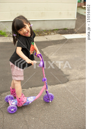 キックボードに乗る女の子の写真素材