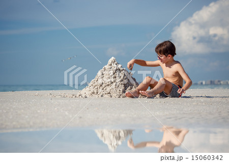 Cute little son building sand castle at beach 15060342