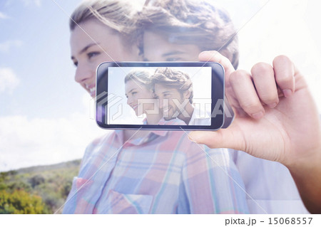 Composite image of hand holding smartphone showing 15068557