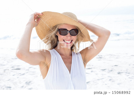 Smiling blonde in white dress wearing sun glasses and straw hat Smiling blonde in white dress wearing sun glasses and straw hat 15068992