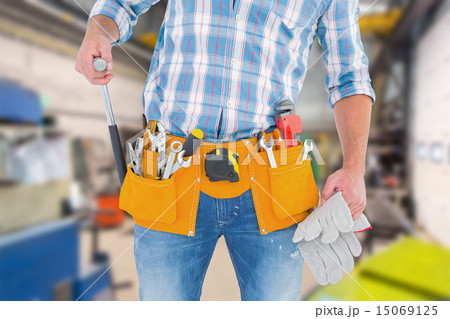 Composite image of midsection of handyman holding hammer and glo Composite image of midsection of handyman holding hammer and glo 15069125