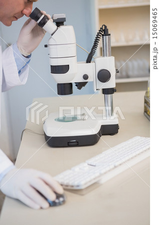 Scientist examining sample with microscope 15069465