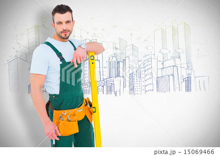 Composite image of carpenter smiling to camera with spirit level 15069466