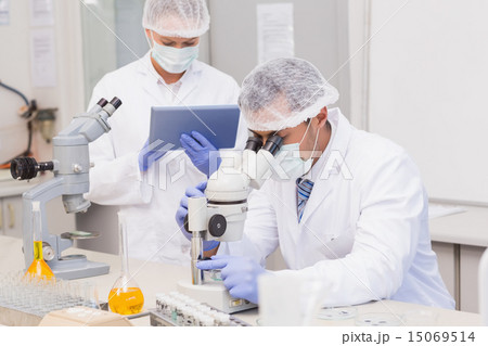 Scientists using tablet pc and microscope 15069514