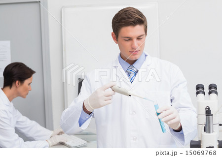Scientists working attentively with test tube and computer Scientists working attentively with test tube and computer 15069768