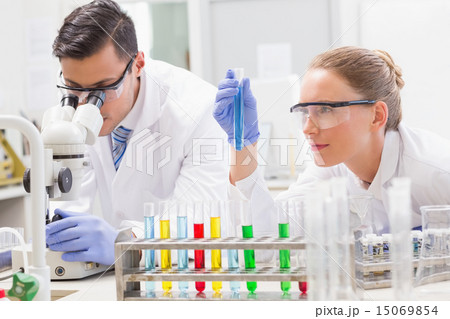 Focused scientists examining test tube Focused scientists examining test tube 15069854