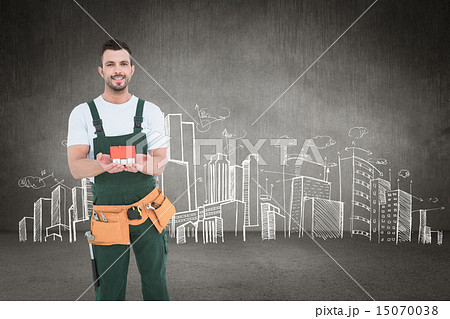 Composite image of happy construction worker holding house model 15070038