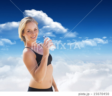 Composite image of fit blonde drinking water 15070450